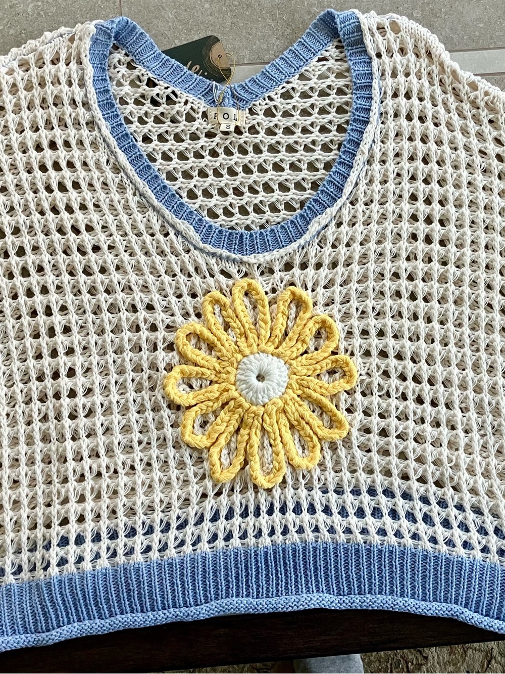 POL Cream Open-Knit Poncho with Blue Trim and Yellow Daisy Appliqué